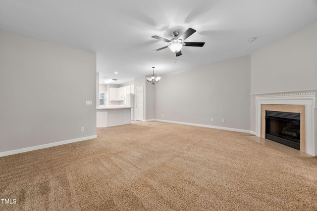 unfurnished living room featuring ceiling fan with notable chandelier and light colored carpet