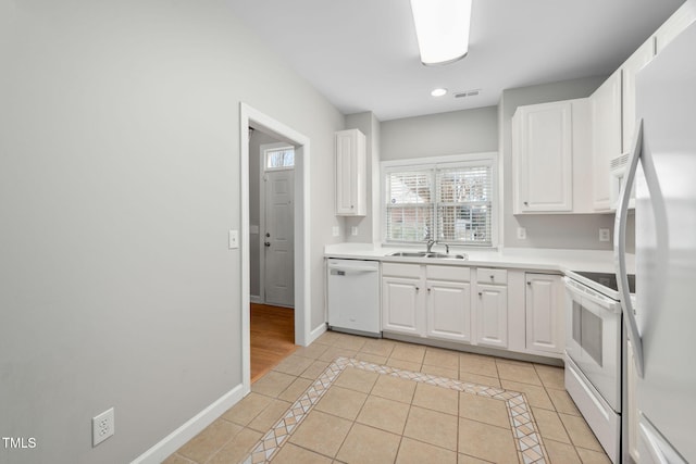 kitchen featuring sink, white cabinetry, white appliances, and light tile patterned floors