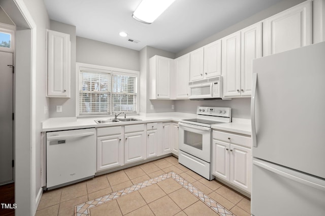 kitchen with sink, white appliances, white cabinets, and light tile patterned floors