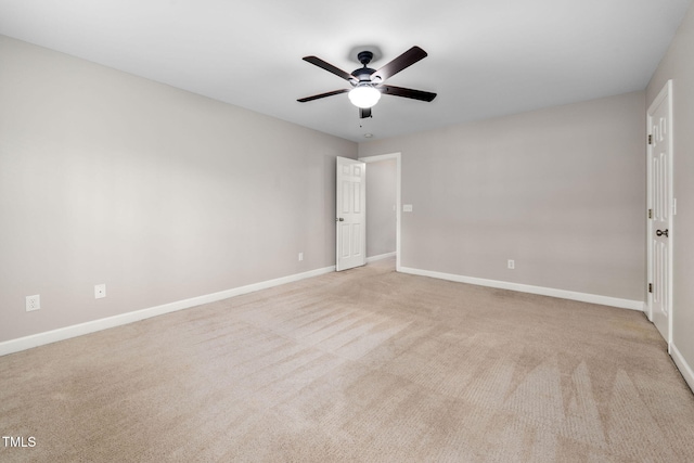 spare room featuring light colored carpet and ceiling fan