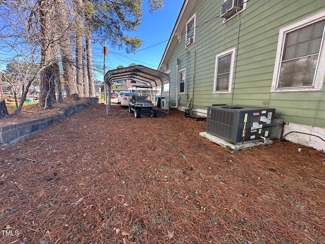 view of yard with central air condition unit and a carport