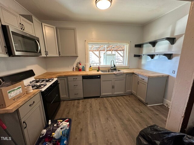 kitchen featuring sink, appliances with stainless steel finishes, gray cabinets, and wood counters