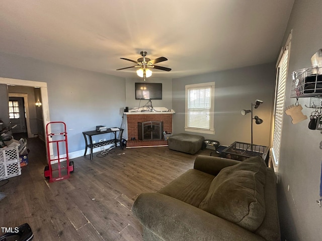 living room with hardwood / wood-style flooring, a brick fireplace, and ceiling fan