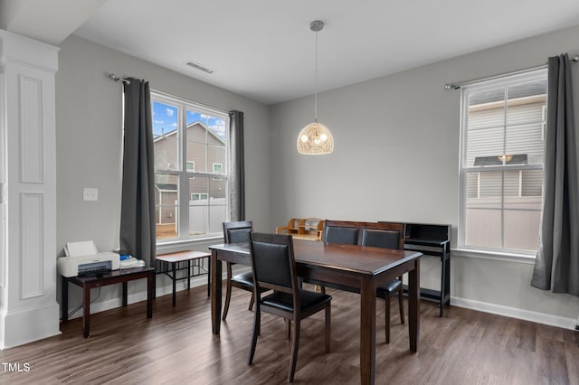 dining area with dark hardwood / wood-style floors and a notable chandelier