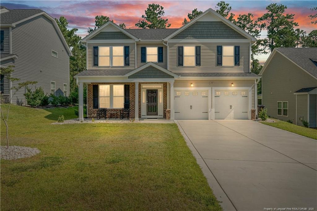 craftsman-style home featuring a garage and a yard