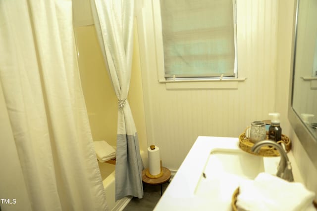 bathroom featuring shower / bath combination with curtain and sink