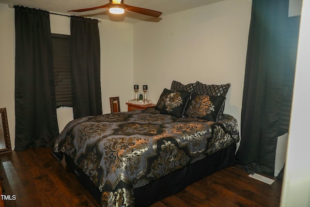 bedroom with dark hardwood / wood-style flooring and ceiling fan