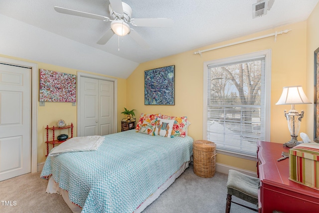 carpeted bedroom with baseboards, vaulted ceiling, a textured ceiling, visible vents, and ceiling fan