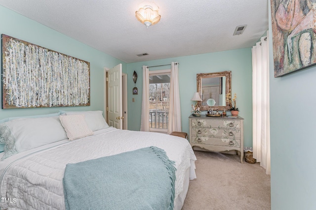 bedroom with light carpet, visible vents, and a textured ceiling