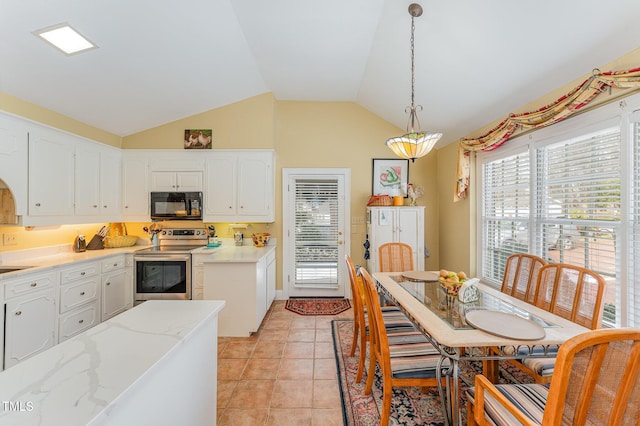 kitchen featuring pendant lighting, light tile patterned floors, black microwave, white cabinets, and stainless steel electric range