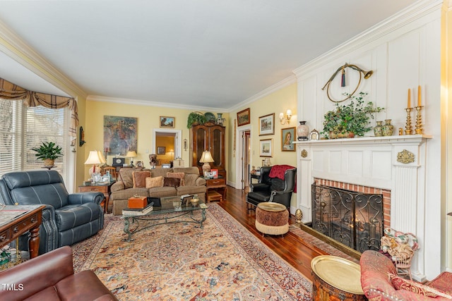living room featuring crown molding, wood finished floors, and a brick fireplace