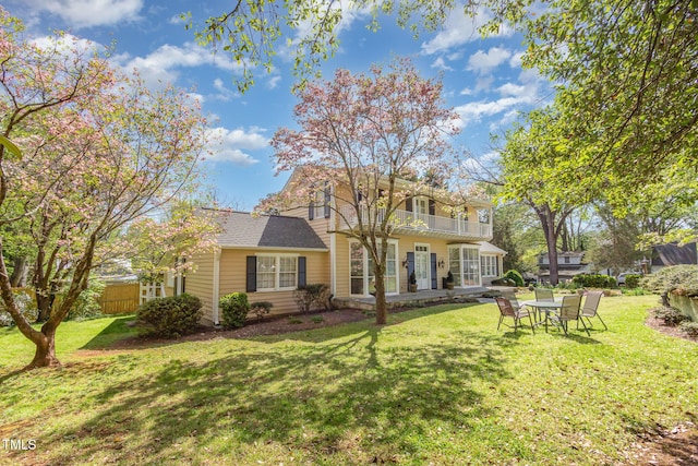 exterior space with a front yard, fence, and a balcony