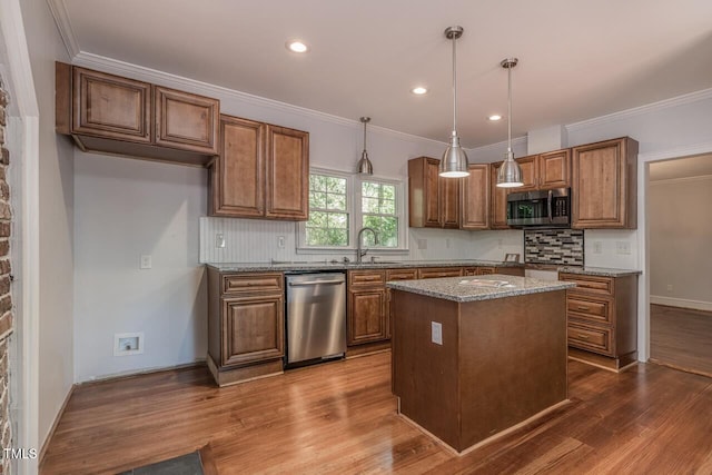 kitchen with stainless steel appliances, a kitchen island, stone countertops, and decorative light fixtures