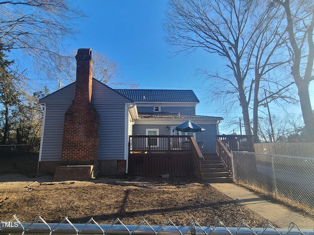 rear view of property featuring a wooden deck