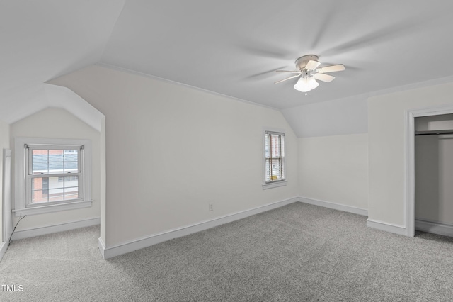 unfurnished bedroom featuring vaulted ceiling, light colored carpet, a closet, and ceiling fan