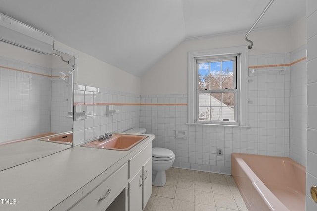 full bathroom featuring tile walls, vanity, vaulted ceiling, toilet, and tiled shower / bath