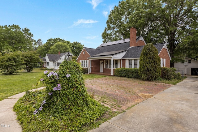 801 Williamsboro St, Oxford, NC 27565 - bungalow-style home featuring a front lawn, covered porch, a chimney, brick siding, and roof mounted solar panels