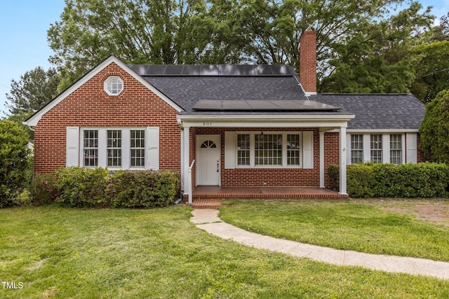 801 Williamsboro St, Oxford, NC 27565 - bungalow-style home featuring a front lawn, a chimney, brick siding, roof mounted solar panels, and a porch
