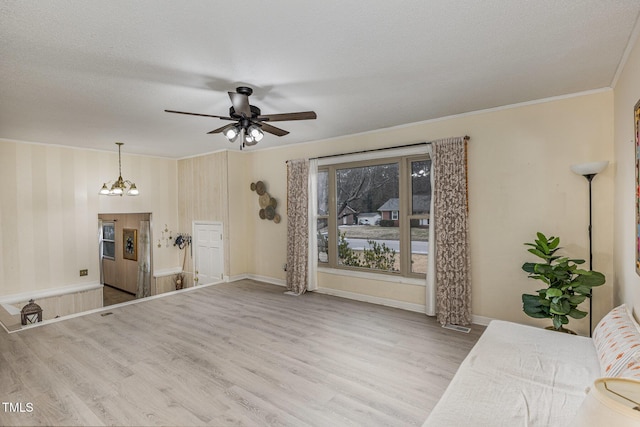 unfurnished living room featuring crown molding, ceiling fan with notable chandelier, light hardwood / wood-style floors, and a textured ceiling