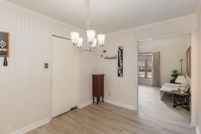 dining space with crown molding, wood-type flooring, and a chandelier