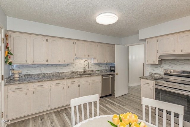 kitchen featuring stainless steel appliances, sink, and stone counters