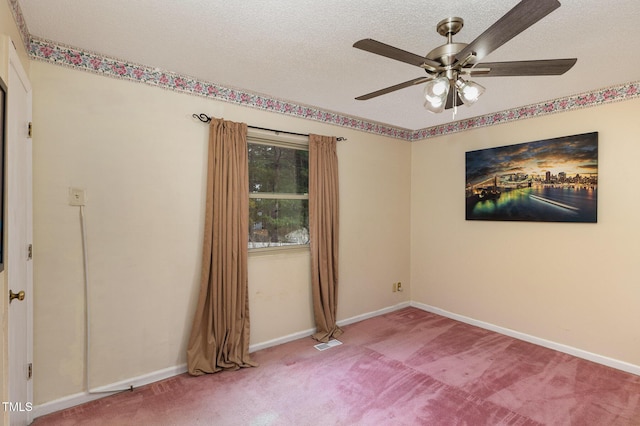 carpeted spare room with ceiling fan and a textured ceiling