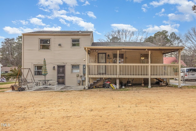 back of property with a yard and a patio