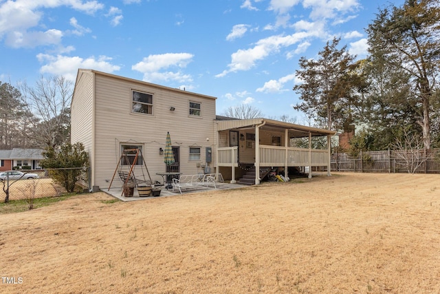 rear view of house featuring a lawn and a patio