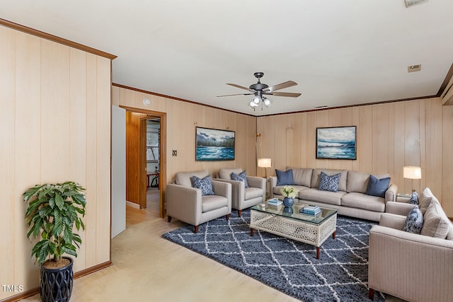 living room featuring crown molding, ceiling fan, and wood walls