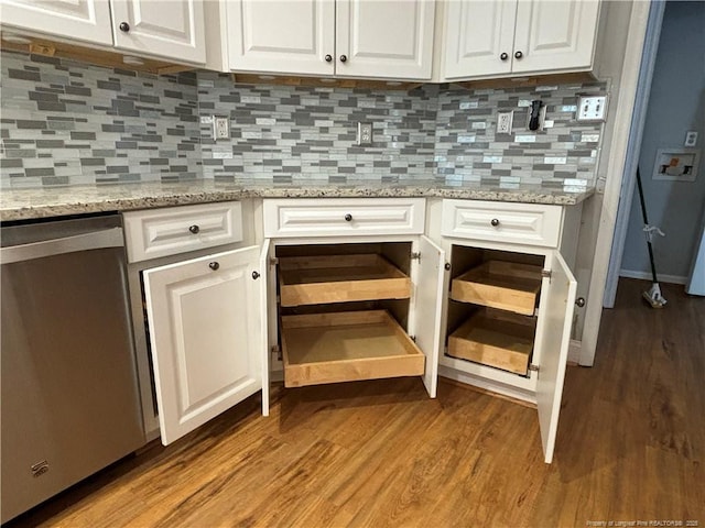 interior details with wood-type flooring, dishwasher, white cabinetry, light stone countertops, and decorative backsplash