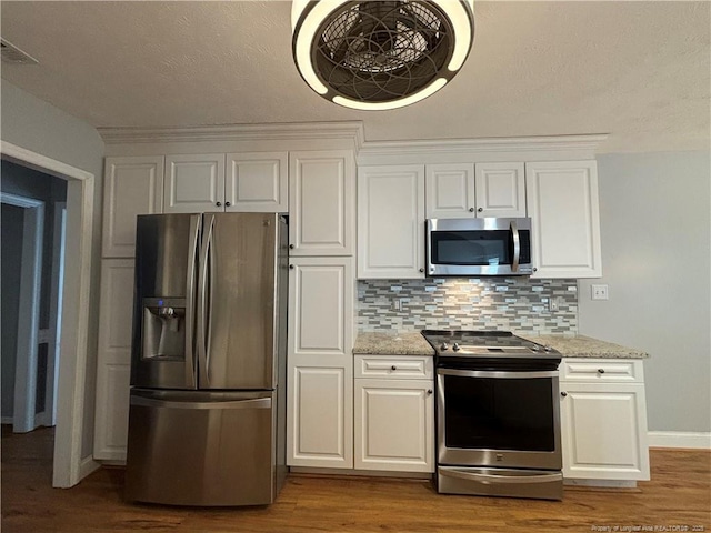 kitchen featuring light stone counters, white cabinets, tasteful backsplash, and stainless steel appliances