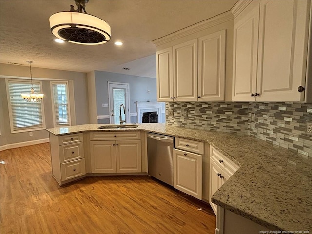 kitchen featuring white cabinetry, tasteful backsplash, sink, kitchen peninsula, and stainless steel dishwasher