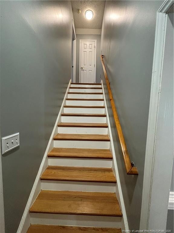 staircase with a textured ceiling