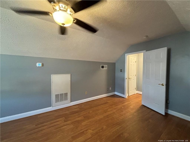 additional living space featuring hardwood / wood-style flooring, a textured ceiling, lofted ceiling, and ceiling fan