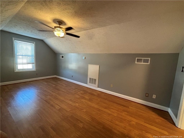 bonus room with hardwood / wood-style flooring, ceiling fan, a textured ceiling, and lofted ceiling