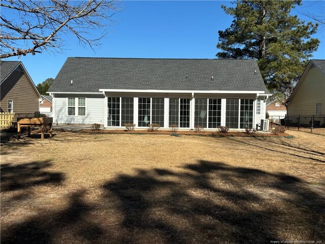 back of house with cooling unit and a lawn