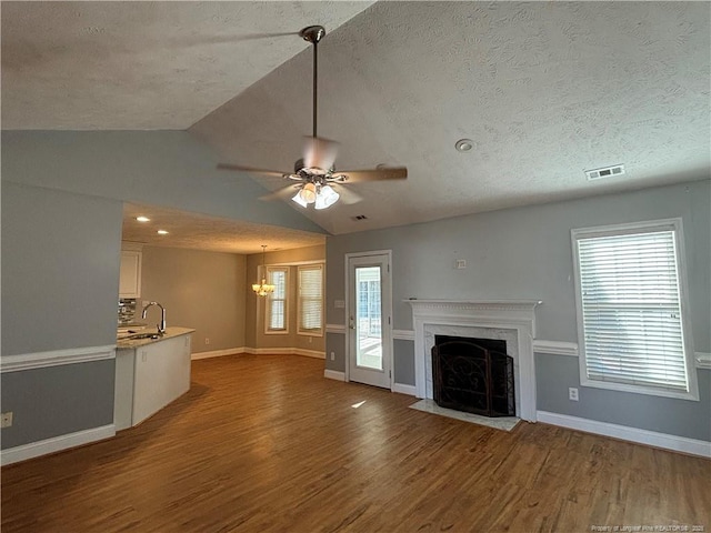 unfurnished living room with hardwood / wood-style flooring, plenty of natural light, a fireplace, and lofted ceiling