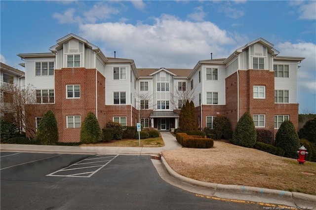 view of building exterior featuring uncovered parking and a residential view