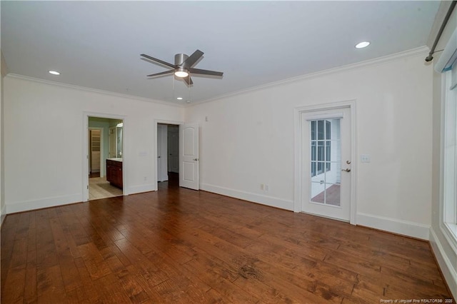 empty room with ornamental molding, wood-type flooring, and baseboards