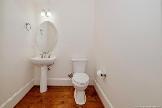 bathroom featuring baseboards, toilet, and wood finished floors