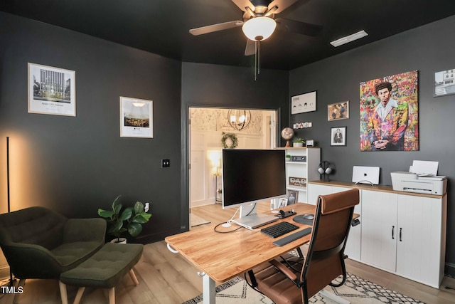 office space featuring ceiling fan with notable chandelier and light hardwood / wood-style flooring