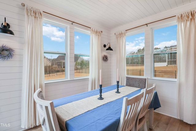 dining space with hardwood / wood-style flooring, wooden ceiling, and a wealth of natural light