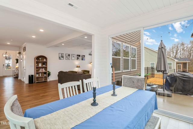 dining area featuring hardwood / wood-style floors and beamed ceiling