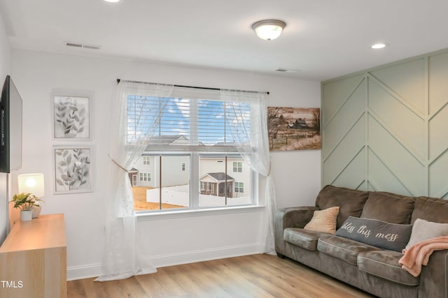 living room with a healthy amount of sunlight and light hardwood / wood-style floors