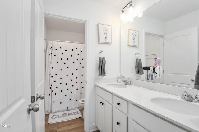 bathroom featuring vanity, curtained shower, wood-type flooring, and toilet