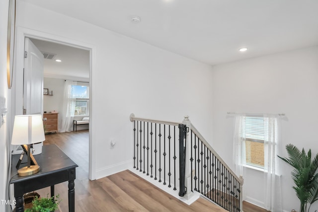 corridor with hardwood / wood-style flooring and a healthy amount of sunlight