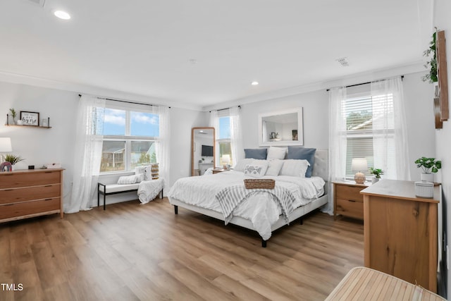 bedroom with crown molding and light hardwood / wood-style floors