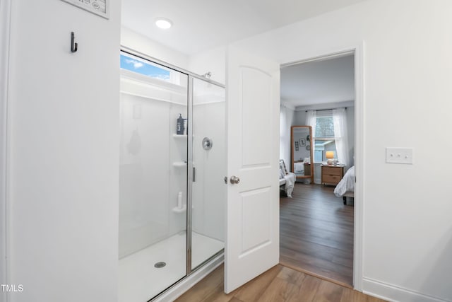 bathroom with hardwood / wood-style floors and an enclosed shower