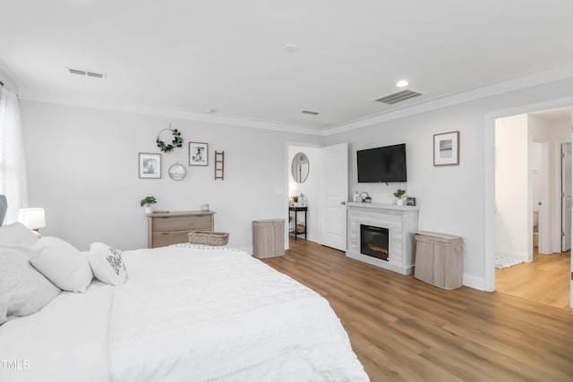 bedroom with hardwood / wood-style floors and crown molding