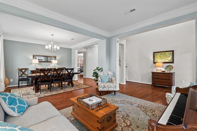 living room featuring an inviting chandelier, hardwood / wood-style flooring, and ornamental molding